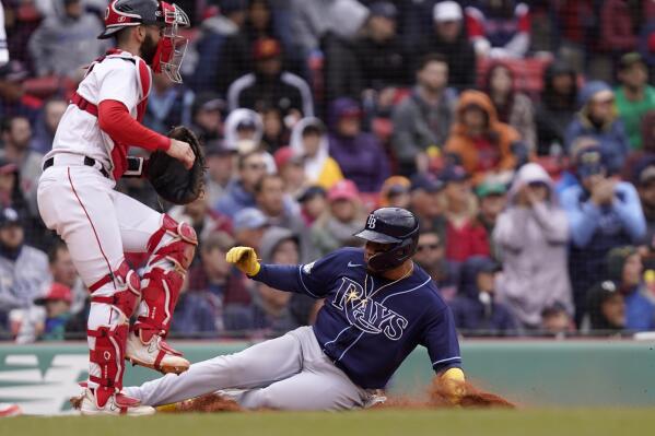 Tampa Bay Rays' Isaac Paredes, right, scores on a fielding error by Boston Red Sox's Masataka Yoshida (not shown) following a single hit by Rays' Manuel Margot as Red Sox's Connor Wong, left, is unable to tag him in fourth inning of a baseball game, Sunday, June 4, 2023, in Boston. (AP Photo/Steven Senne)