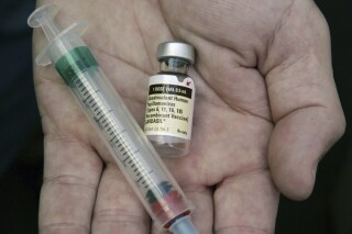 FILE - A doctor holds a vial of the human papillomavirus (HPV) vaccine Gardasil in Chicago on Aug. 28, 2006. Research published Thursday, May 23, 2024, by the American Society of Clinical Oncology suggests the HPV vaccine is preventing throat cancer in men, as well as cervical cancer in women, but fewer boys than girls are getting the shots in the United States. (AP Photo/Charles Rex Arbogast, File)
