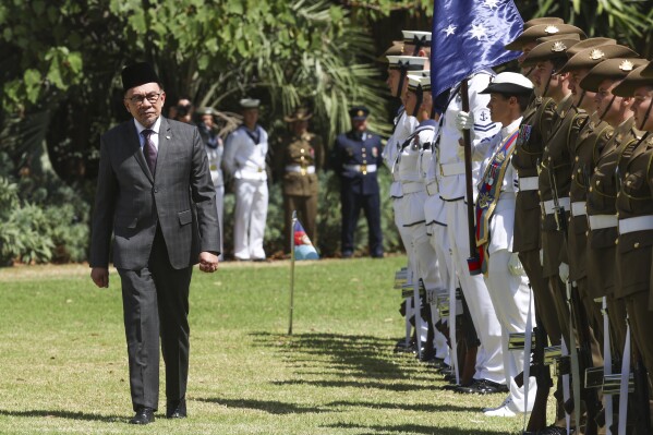 The Prime Minister of Malaysia Anwar Ibrahim inspects a guard of honor during a ceremonial welcome at Government House ahead of the ASEAN-Australia Special Summit in Melbourne, Australia, Monday, March 4, 2024. An increasingly assertive China and a humanitarian crisis in Myanmar are likely to be high on the agenda when Southeast Asian leaders meet in Australia for a rare summit March 4-6. (AP Photo/Hamish Blair)
