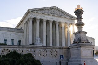 FILE - In this Nov. 10, 2020, file photo the sun rises behind the U.S. Supreme Court in Washington. The Supreme Court seemed concerned Tuesday, Dec. 1, about the impact of siding with food giants Nestle and Cargill and ending a lawsuit that claims they knowingly bought cocoa beans from farms in Africa that used child slave labor. The court was hearing arguments in the case by phone because of the coronavirus pandemic. (AP Photo/Alex Brandon, File)