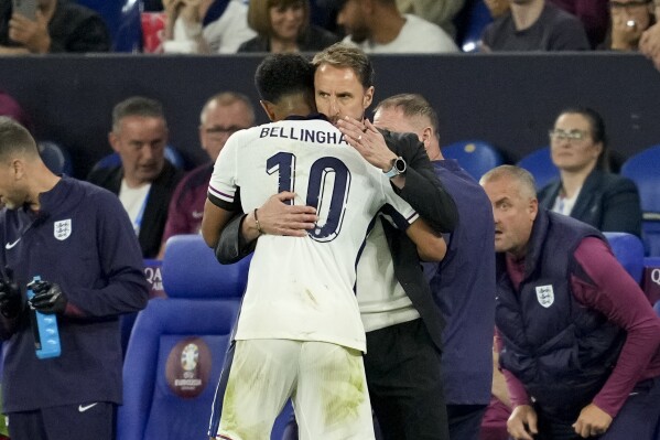 England's Jude Bellingham gets a hug from England's manager Gareth Southgate after being substituted during a Group C match between Serbia and England at the Euro 2024 soccer tournament in Gelsenkirchen, Germany, Sunday, June 16, 2024. (AP Photo/Andreea Alexandru)