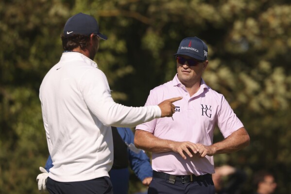 CORRECTS FIRST NAME TO ZACH, NOT ZAC AS ORIGINALLY SENT - United States' Zach Johnson, right, speaks to United States' Brooks Koepka during a practice round for the British Open Golf Championships at the Royal Liverpool Golf Club in Hoylake, England, Monday, July 17, 2023. The Open starts Thursday, July 20. (AP Photo/Peter Morrison)