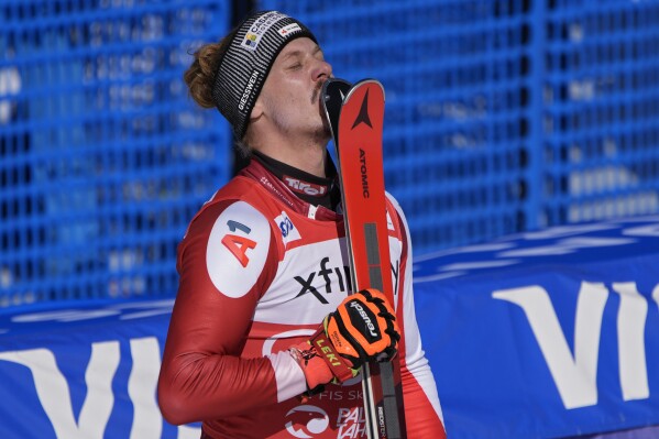 Austria's Manuel Feller kisses his skis after placing first in a men's World Cup slalom skiing race Sunday, Feb. 25, 2024, in Olympic Valley, Calif. (AP Photo/John Locher)