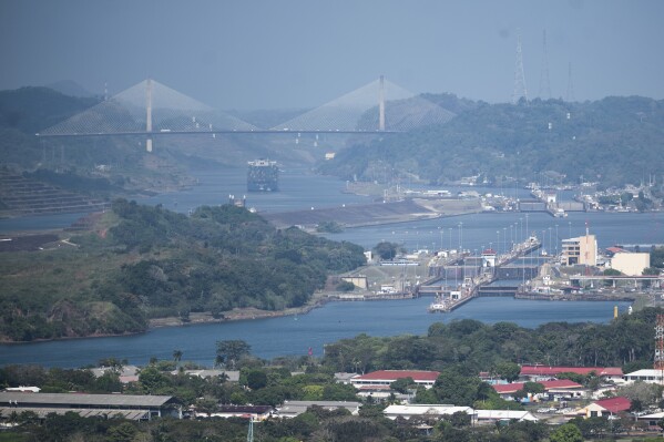 A cargo ship waits near the Centennial Bridge for transit through the Panama Canal locks, in Panama City, Wednesday, Jan. 17, 2024. A severe drought that began last year has forced authorities to slash ship crossings by 36% in the Panama Canal, one of the world’s most important trade routes. (AP Photo/Agustin Herrera)