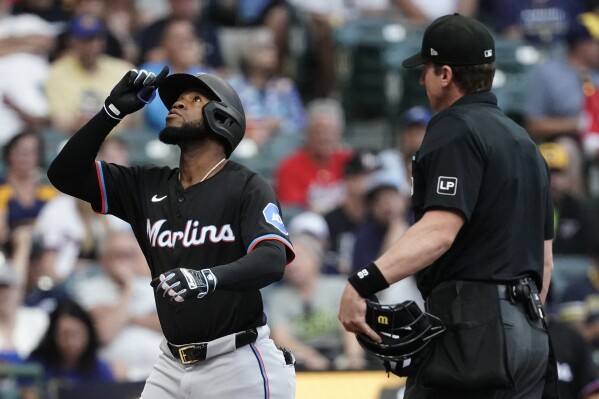 Miami Marlins' Bryan De La Cruz, left, gestures after hitting a two-run home run during the first inning of a baseball game against the Milwaukee Brewers, Friday, July 26, 2024, in Milwaukee. (ĢӰԺ Photo/Aaron Gash)