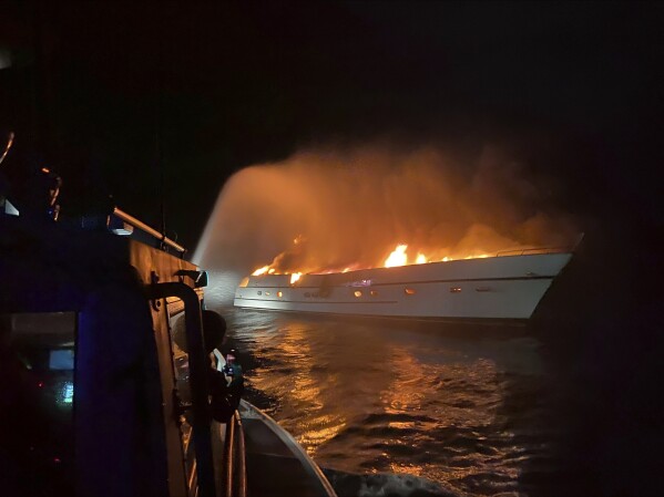 Emergency personnel try to put a fire on a sailboat off the coast of Cape Henry, Va. early Friday, March 8, 2024. Three people were rescued as the U.S. Coast Guard asked the Virginia Beach Fire Department’s fire boat crews to help respond to the fire about 3 miles (4.8 km) off the coast of Cape Henry around 3:40 a.m., department spokesperson said in an email. (Virginia Beach Fire Department via AP)