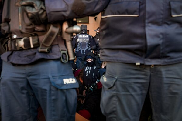 Police officers surround protesters blocking traffic outside the District Court to show solidarity with a person suspected of assaulting a police officer during protests against a ruling restricting abortions in Warsaw, Poland, Thursday, Nov. 19, 2020. Polish police came under criticism on for using tear gas and force on mostly female and young protesters during the latest in a string of women-led protests against a top court ruling restricting abortion. (AP Photo/Agata Grzybowska)