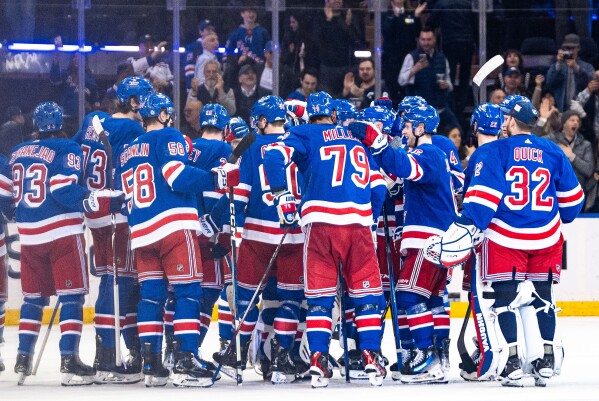 New York Rangers players gather on the ice after Adam Fox's overtime goal against the Philadelphia Flyers in an NHL hockey game Tuesday, March 26, 2024 in New York. (AP Photo/Peter K. Afriyie)