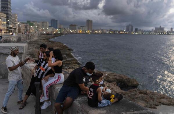 La gente pasa la tarde en el Malecón de La Habana, Cuba, el miércoles 29 de septiembre de 2021. Las autoridades de Cuba han comenzado a relajar las restricciones de COVID en varias ciudades como La Habana. (AP Foto/Ramon Espinosa)