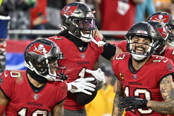 Tampa Bay Buccaneers running back Rachaad White (1) celebrates a 2-yard touchdown run with teammates during the second half of an NFL football game against the Jacksonville Jaguars Sunday, Dec. 24, 2023, in Tampa, Fla. (AP Photo/Jason Behnken)