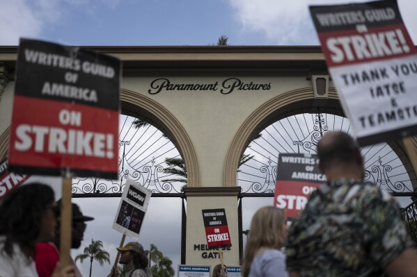FILE - Demonstrators walk with signs during a rally outside the Paramount Pictures Studio in Los Angeles, Thursday, Sept. 21, 2023. A tentative deal was reached, Sunday, Sept. 24, 2023, to end Hollywood’s writers strike after nearly five months. (AP Photo/Jae C. Hong, File)