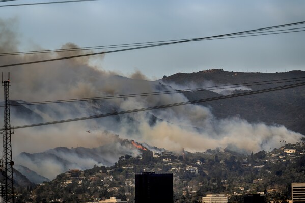 Small fires are seen along a hillside burn the Brentwood section of Los Angeles on Wednesday, Jan. 8, 2025. (AP Photo/Richard Vogel)
