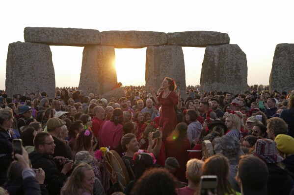 Revelers gather at the ancient stone circle Stonehenge to celebrate the Summer Solstice, the longest day of the year, near Salisbury, England, Wednesday, June 21, 2023. Druids, pagans, hippies, local residents, tourists and costumed witches and wizards have gathered around a prehistoric stone circle on a plain in southern England to express their devotion to the sun. (AP Photo/Kin Cheung)