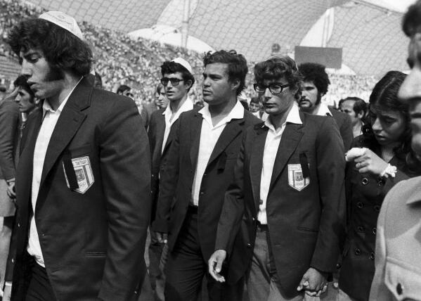 FILE - Members of Israel's Olympic team place black ribbons in their pockets after a memorial service mourning their comrades killed in Tuesday's Arab terrorists attack and subsequent police shoot-out leave the Olympic stadium in Munich, then West Germany, Wednesday, Sept. 6, 1972. The German government said Friday, April 21, 2023 it has set up an international commission of experts to review the events surrounding the 1972 attack on the Munich Olympics, a panel that was part of an agreement reached last year with relatives of the 11 Israeli athletes who were killed by Palestinian militants. (AP Photo, File)