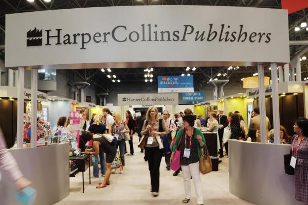 FILE - Attendees at BookExpo America visit the HarperCollins Publishers booth in New York on May 28, 2015. Some 250 copy editors, marketing assistants and other employees at HarperCollins Publishers went on strike Thursday, with the two sides differing over wages and benefits, diversity policy and union protection. (AP Photo/Mark Lennihan, File)