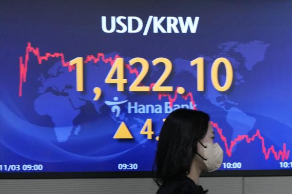 A currency trader walks near the screen showing the foreign exchange rate between U.S. dollar and South Korean won at a foreign exchange dealing room in Seoul, South Korea, Thursday, Nov. 3, 2022. Markets: Asian stock markets tumbled Thursday after the Federal Reserve added to recession fears of a possible recession by saying it wasn't finished raising U.S. interest rates to cool inflation. (AP Photo/Lee Jin-man)