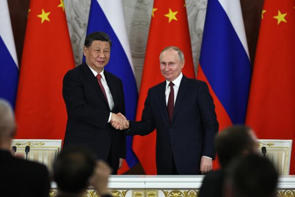 FILE - Russian President Vladimir Putin, right, and Chinese President Xi Jinping shake hands after speaking to the media during a signing ceremony following their talks at The Grand Kremlin Palace, in Moscow, Russia, March 21, 2023. China’s leader Xi just concluded his three-day visit with Russian President Vladimir Putin, a warm affair in which the two men praised each other and spoke of a profound friendship. It’s a high in a complicated, centuries-long relationship in which the two countries have been allies and enemies.(Mikhail Tereshchenko, Sputnik, Kremlin Pool Photo via AP, File)