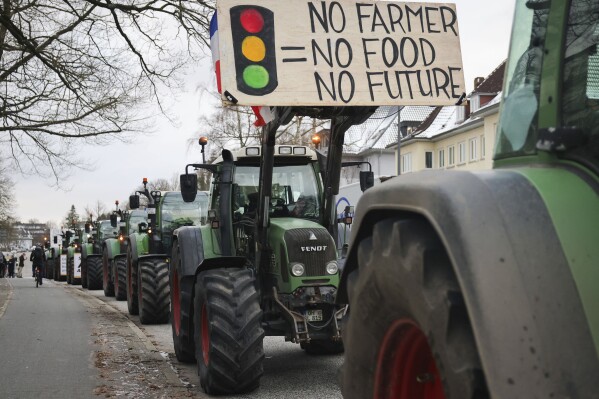 Farmers demonstrate with their tractors in front of the state parliament in Kiel, Germany, Monday, Jan. 8, 2024. Farmers blocked highway access roads in parts of Germany Monday and gathered for demonstrations, launching a week of protests against a government plan to scrap tax breaks on diesel used in agriculture. (Christian Charisius/dpa via AP)