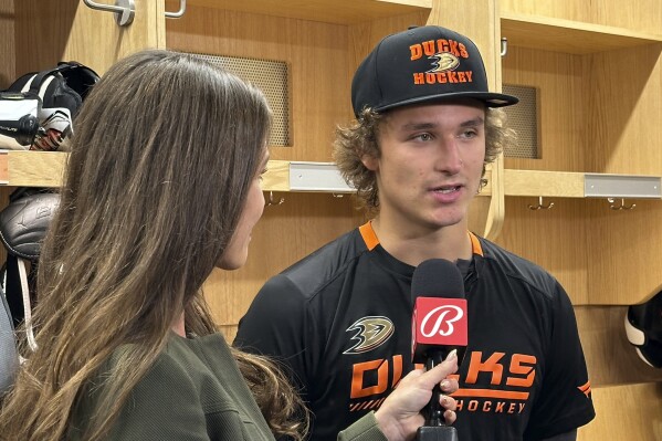 Anaheim Ducks center Trevor Zegras does a television interview after NHL hockey practice at the Great Park Ice Complex in Irvine, Calif., Tuesday, Oct. 3, 2023. Zegras agreed to a three-year, $17.25 million contract with the Ducks on Monday. He led the team in scoring with 65 points last season. (AP Photo/Joe Reedy)