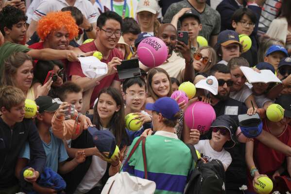 Italy's Jannik Sinner signs autographs to fans after beating Jiri Lehecka of the Czech Republic during their third round match of the French Tennis Open, at the Roland-Garros stadium, in Paris, Saturday, May 31, 2025. (AP Photo/Thibault Camus)