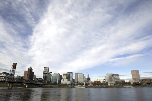 FILE - The Portland, Ore., skyline is visible on the bank of the Willamette River, Dec. 3, 2014. A state appeals court in Oregon ruled Wednesday, Dec. 20, 2023, that a state program designed to limit and drastically reduce greenhouse gas emissions from fossil fuel companies is invalid. (AP Photo/Don Ryan, File)