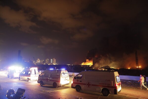 Ambulances drive past the site of a massive explosion in Beirut, Lebanon, Tuesday, Aug. 4, 2020. (AP Photo/Hassan Ammar)