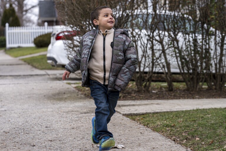 Four-year-old Omar Abu Kuwaik strolls down the sidewalk near the Global Medical Relief Fund residence, Tuesday, Jan. 30, 2024, in the Staten Island borough of New York. Omar Abu Kuwaik is far from his home in Gaza. The 4-year-old's parents and sister were killed by an Israeli airstrike, and he lost part of his arm. (AP Photo/Peter K. Afriyie)