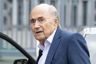 FILE - In this Tuesday, Sept. 1, 2020 file photo, former FIFA President Sepp Blatter, center, appears in front of the building of the Office of the Attorney General of Switzerland, in Bern, Switzerland. Former FIFA president Blatter spent a week in an induced coma after having heart surgery in December, his family said on Thursday, Jan. 21, 2021. The 84-year-old Blatter, who also tested positive for COVID-19 late last year, was well enough only this week to be moved from an intensive care unit at the hospital. (Peter Schneider/Keystone via AP, FIle)
