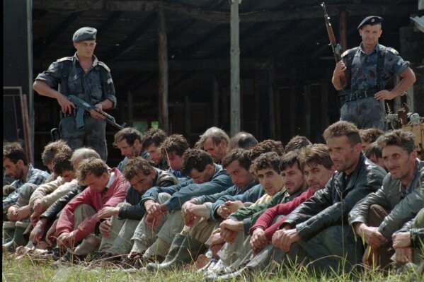 Two Serbian policemen guard a group of Bosnian Muslim men from the Srebrenica enclave that have crossed into Yugoslavia from Bosnia in the Serb town of Uzice,some 250km (155 miles) south of Belgrade, Aug. 5.1995. (ĢӰԺ PHOTO)
