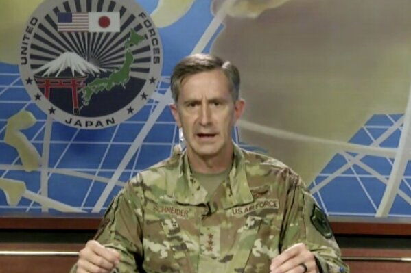 In this image made from an online news conference provided by U.S. Forces Japan, Lt. Gen. Kevin Schneider, Commander of the U.S. Force, speaks from Yokota Air Base, in Tokyo, to reporters, Wednesday, July 29, 2020. Schneider said Wednesday strict measures were in place among his ranks to curb the spread of the coronavirus by military service personnel entering Japan.(U.S. Forces Japan. via AP)