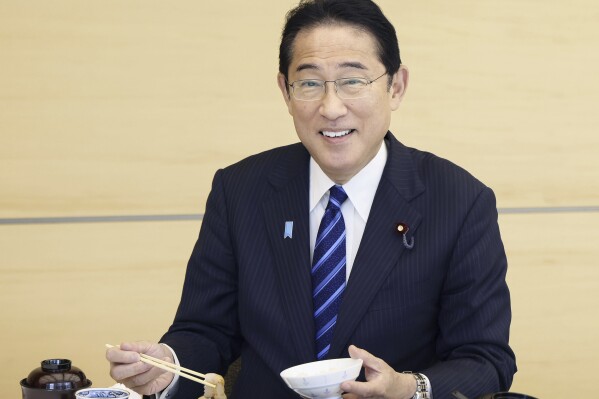In this photo provided by Cabinet Public Affairs Office, Japanese Prime Minister Fumio Kishida eats the seafood from Fukushima prefecture at lunch at the prime minister's office in Tokyo, Japan, Wednesday, Aug. 30, 2023. (Cabinet Public Affairs Office via AP)