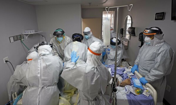 FILE - In this July 6, 2020, file photo, Dr. Joseph Varon, right, leads a team as they try to save the life of a patient unsuccessfully inside the Coronavirus Unit at United Memorial Medical Center, Monday, July 6, 2020, in Houston. The U.S. death toll from the coronavirus topped 200,000 Tuesday, Sept. 22, a figure unimaginable eight months ago when the scourge first reached the world’s richest nation with its sparkling laboratories, top-flight scientists and towering stockpiles of medicines and emergency supplies. (AP Photo/David J. Phillip, File)