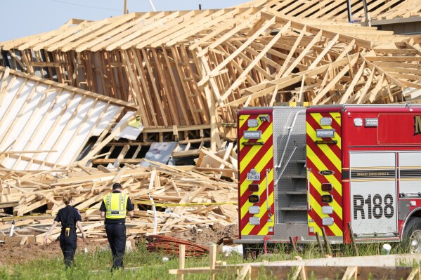 Magnolia Fire officials investigate the scene of a collapsed house that resulted in a fatality on Tuesday, May 28, 2024 in Magnolia, Texas. One construction worker was killed when the frames of two single-family homes that were under construction fell as a strong, fast-moving storm moved across Montgomery County, officials said. (Brett Coomer/Houston Chronicle via AP)