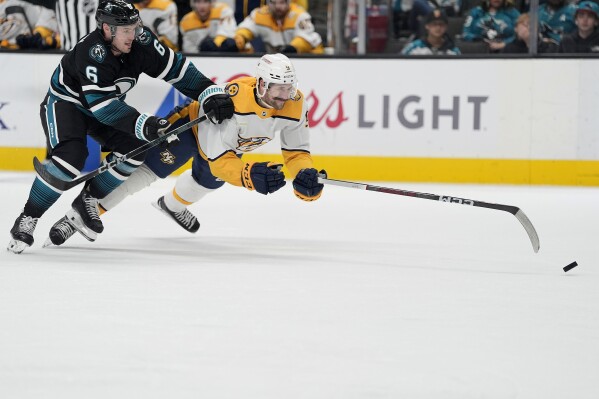 Nashville Predators left wing Filip Forsberg (9) is fouled from behind by San Jose Sharks defenseman Ty Emberson (6) during the second period of an NHL hockey game Saturday, Feb. 24, 2024, in San Jose, Calif. (AP Photo/Tony Avelar)