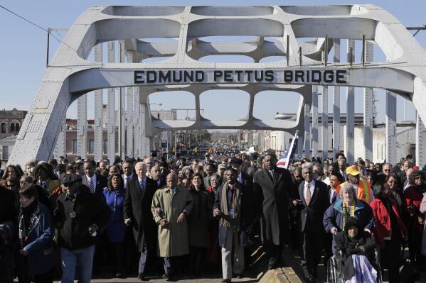 FILE - Vice President Joe Biden and U.S. Rep. John Lewis, D-Ga., lead a group across the Edmund Pettus Bridge in Selma, Ala., on March 3, 2013. Vice President Kamala Harris is traveling to Alabama this weekend to commemorate a key moment of the civil rights movement. Harris will speak in Selma at an event marking the 57th anniversary of “Bloody Sunday,” the day in 1965 when white police attacked Black voting rights marchers. (AP Photo/Dave Martin, File)