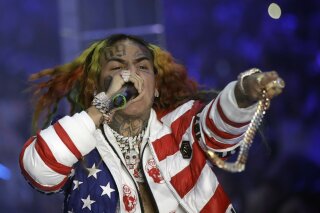 
              FILE- In this Sept. 21, 2018, file photo rapper Daniel Hernandez, known as Tekashi 6ix9ine, performs during the Philipp Plein women's 2019 Spring-Summer collection, unveiled during the Fashion Week in Milan, Italy. Federal authorities say Hernandez is in custody and awaiting a Manhattan court appearance. The Brooklyn-based rapper, whose legal name is Daniel Hernandez, is among four people arrested on racketeering and firearms charges. (AP Photo/Luca Bruno, File)
            