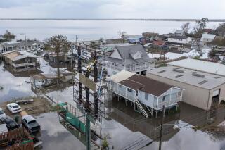 FILE - In this Tuesday, Aug. 31, 2021 file photo, flood waters surround storm damaged homes in Lafourche Parish, La., as residents try to recover from the effects of Hurricane Ida.  The federal government rolled out a new program to calculate flood insurance rates that it says will be more precise and fair. (AP Photo/Steve Helber)