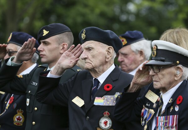 Canadian World War II veteran Dick Brown, second right, and Rod Deon, right, salute as they attend a ceremony at the Beny-sur-Mer Canadian War Cemetery in Reviers, Normandy, France, Wednesday, June 5, 2019. A ceremony was held on Wednesday for Canadians who fought and died on the beaches and in the bitter bridgehead battles of Normandy during World War II. (AP Photo/David Vincent)