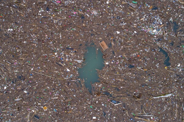 Aerial view of waste floating in the Drina river near Visegrad, Bosnia, Wednesday, Jan. 10, 2024. Tons of waste dumped in poorly regulated riverside landfills or directly into the rivers across three Western Balkan countries end up accumulating during high water season in winter and spring, behind a trash barrier in the Drina River in eastern Bosnia. (AP Photo/Armin Durgut)