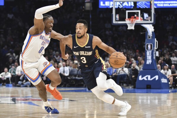 New Orleans Pelicans guard CJ McCollum (5) pushes past Oklahoma City Thunder forward Jalen Williams (8) in the second half of an NBA basketball game, Wednesday, Nov. 1, 2023, in Oklahoma City. (AP Photo/Kyle Phillips)