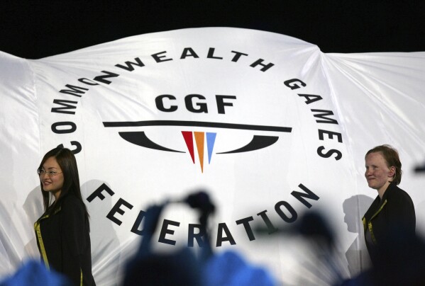 FILE - The Commonwealth Games Federation flag is carried into the arena during the Commonwealth Games opening ceremony in Melbourne, Australia on March 15, 2006. Australia's Victoria state Premier Daniel Andrews on Tuesday, July 18, 2023, said his government has withdrawn as host of the 2026 Commonwealth Games because of a massive increase in the projected cost of staging the multi-sports event. (AP Photo/Mark Baker, File)