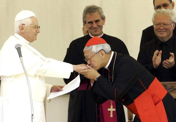 FILE - Chinese Cardinal Joseph Zen, right, Bishop of Hong Kong, kisses the hand of Pope Benedict XVI after the traditional Angelus prayer in Lorenzago di Cadore, near Belluno, Italy, Sunday, July 22, 2007. Zen will leave the southern Chinese city of Hong Kong this week to pay his respects to the late Pope Emeritus Benedict XVI in Vatican City, his secretary said on Tuesday, Jan. 3, 2022. (AP Photo/Antonio Calanni, File)