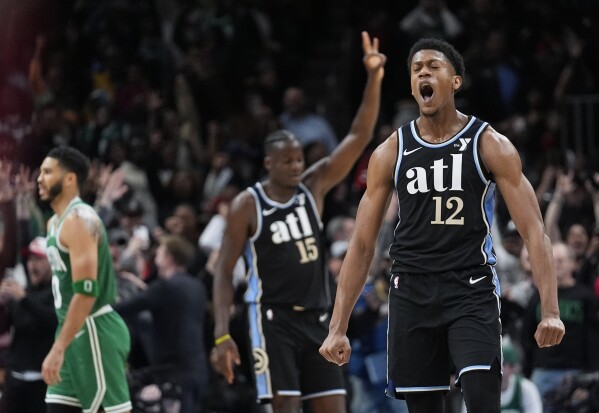 Atlanta Hawks forward De'Andre Hunter (12) reacts after hitting a three-point basket late in the second half of an NBA basketball game against the Boston Celtics Monday, March 25, 2024, in Atlanta. The Hawks won. (AP Photo/John Bazemore)