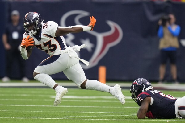 Denver Broncos running back Javonte Williams (33) gets around Houston Texans linebacker Denzel Perryman (6) in the second half of an NFL football game Sunday, Dec. 3, 2023, in Houston. (AP Photo/Eric Christian Smith)