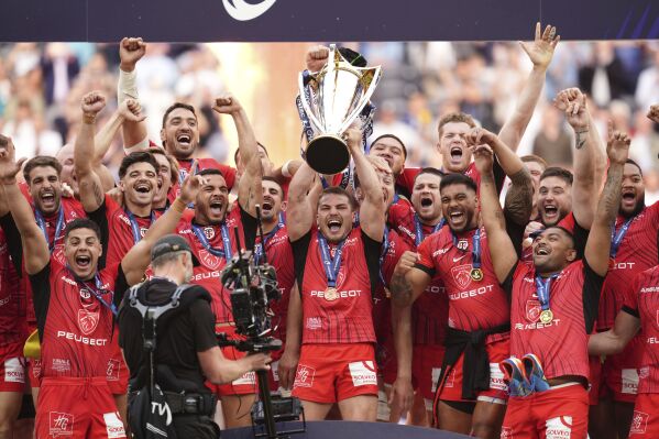Toulouse's team players celebrate with the trophy as they won the European Champions Cup rugby union final between Leinster and Toulouse at the Tottenham Hotspur Stadium, London, Saturday, May 25, 2024. (Adam Davy/PA via AP)