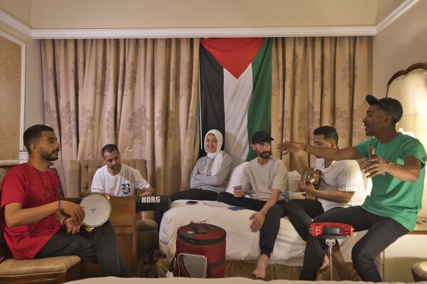 From left, Fares Anbar, Abood Qassim, Rahaf Shamaly, Hamada Nasrallah, Ahmed Haddad and Said Fadel of the Gaza Strip-based Sol Band prepare for a practice session in Doha, Qatar, Friday, May, 3, 2024. (AP Photo/Lujain Jo)
