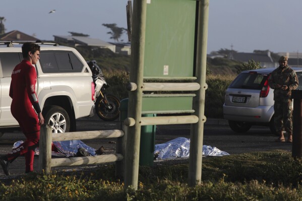 The bodies of two South Africa Navy personal lay covered after being recovered from the sea at Kommetjie, ear Cape own, South Africa, Wednesday, Sept. 20, 2023. The National Sea Rescue Institute (NSRI) said that two SA Navy divers were dead and five were rescued at sea just off the coast of Kommetjie. (AP Photo/Halden Krog)