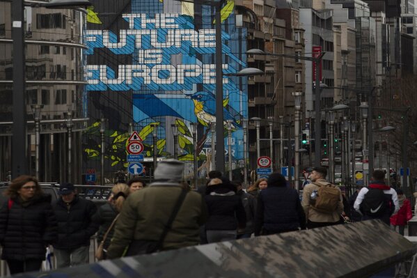 People walk down a main avenue in the EU Quarter of Brussels, Monday, Jan. 27, 2020. The U.K. is due to leave the EU on Friday, the first nation in the bloc to do so. It then enters an 11-month transition period in which Britain will continue to follow the bloc's rules while the two sides work out new deals on trade, security and other areas., 2020. (AP Photo/Virginia Mayo)