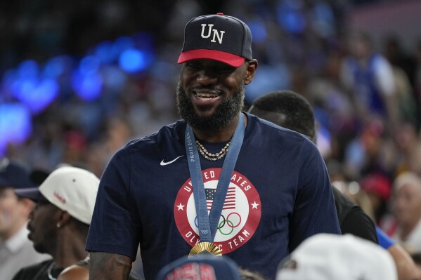 LeBron James wearing his gold medal is seen during a women's gold medal basketball game at Bercy Arena at the 2024 Summer Olympics, Sunday, Aug. 11, 2024, in Paris, France. (AP Photo/Michael Conroy)