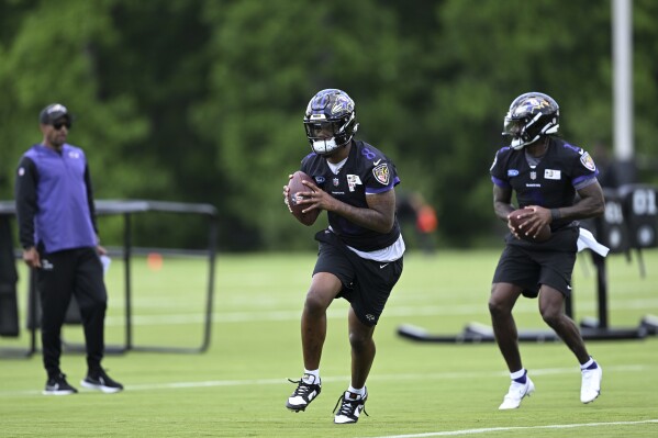 Baltimore Ravens quarterback Lamar Jackson, left, and Tyler Huntley workout during NFL football practice Wednesday, June 14, 2023, in Owings Mills, Md. (AP Photo/Gail Burton)